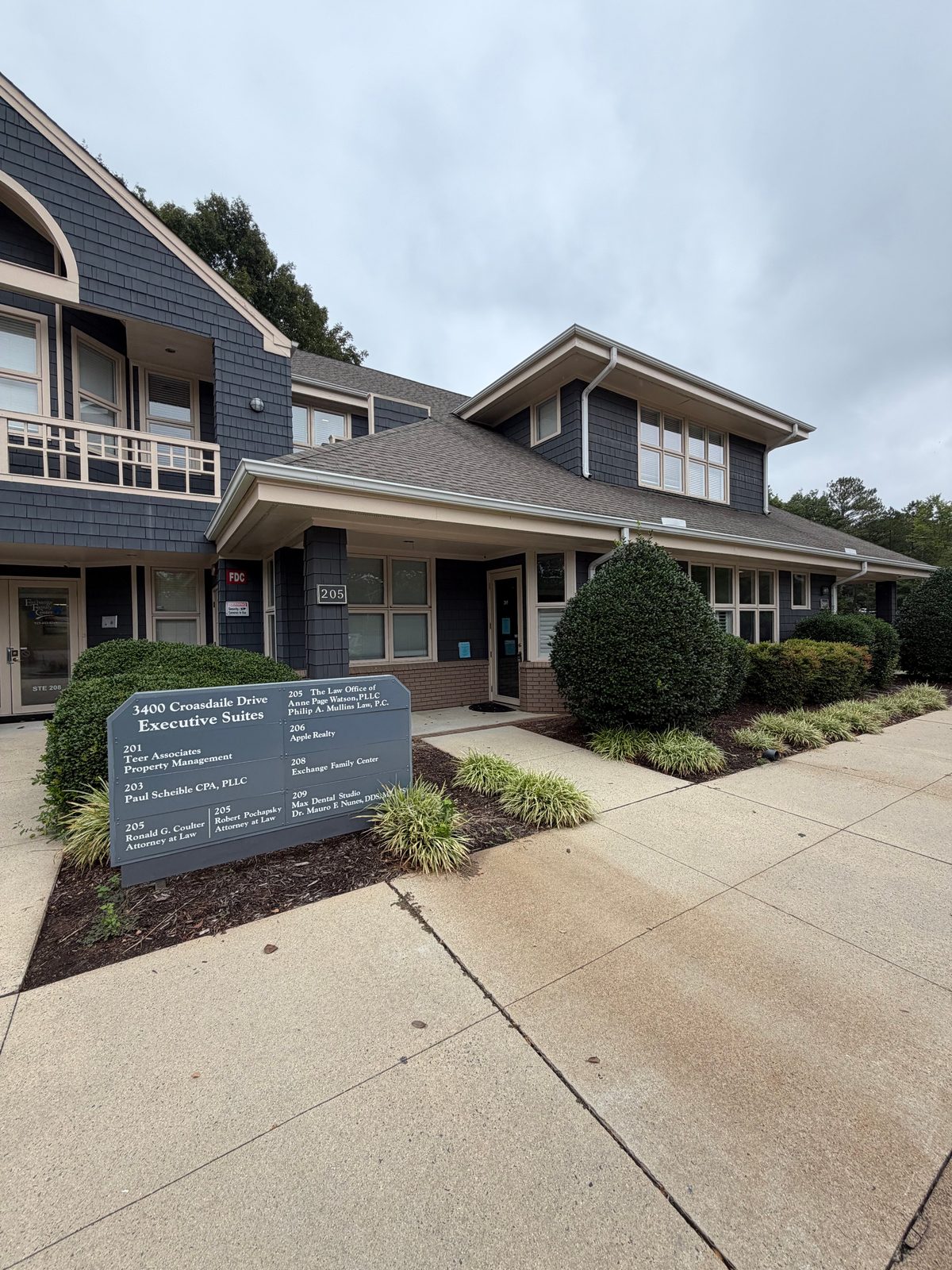 Exterior of 3400 Croasdaile Drive Executive Suites, with the Suite 205 entrance beside the directory sign
