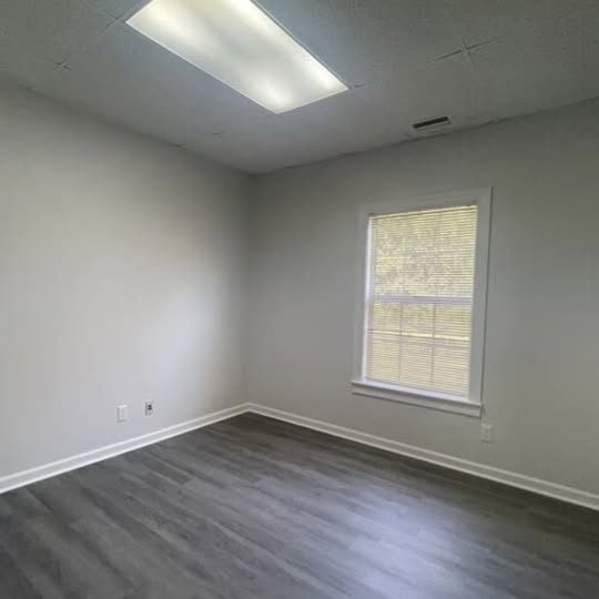 Bright private office in Suite 105A with gray flooring, a window and overhead lighting